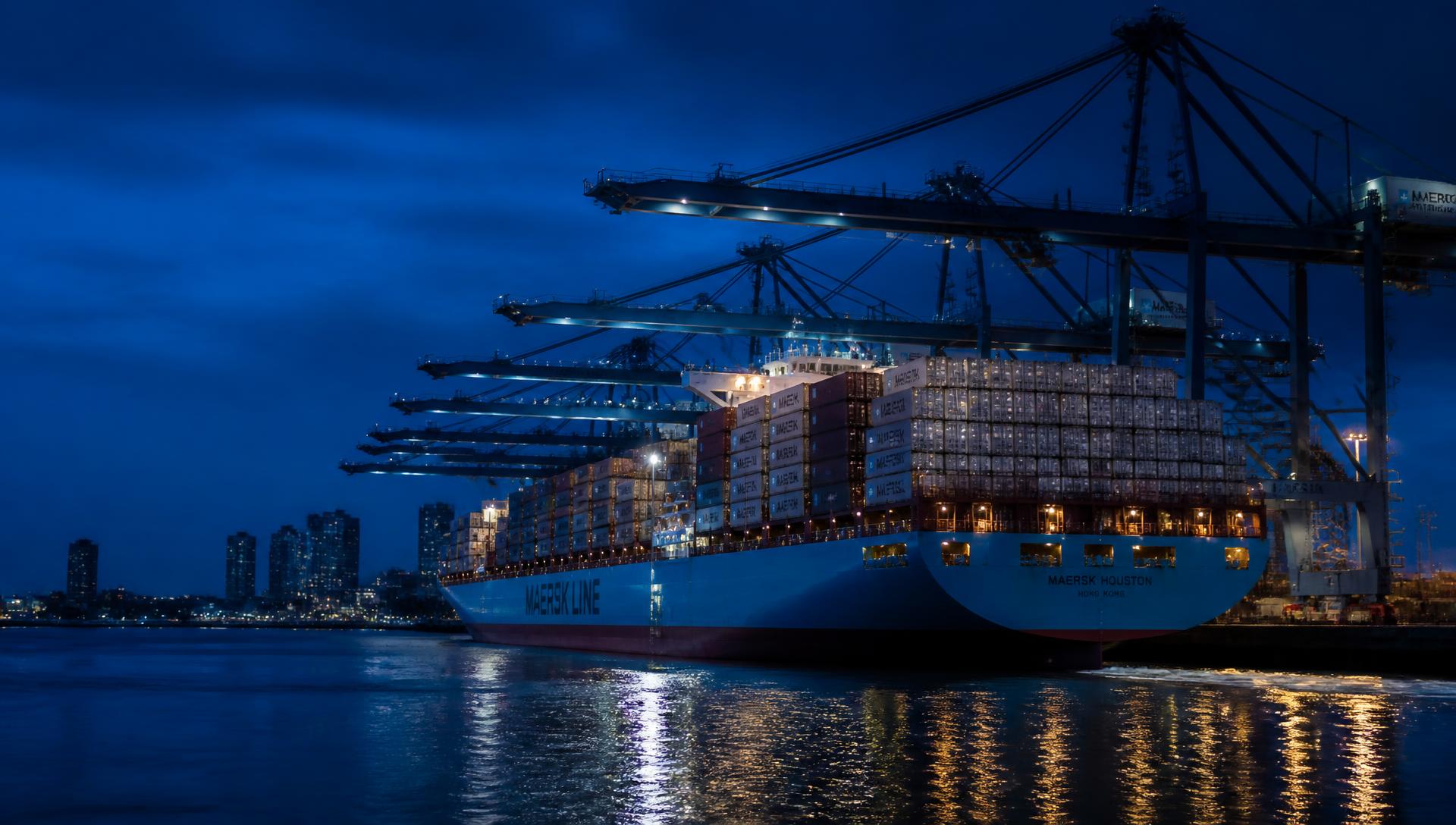 Container ship berthed at a modern container terminal at blue hour